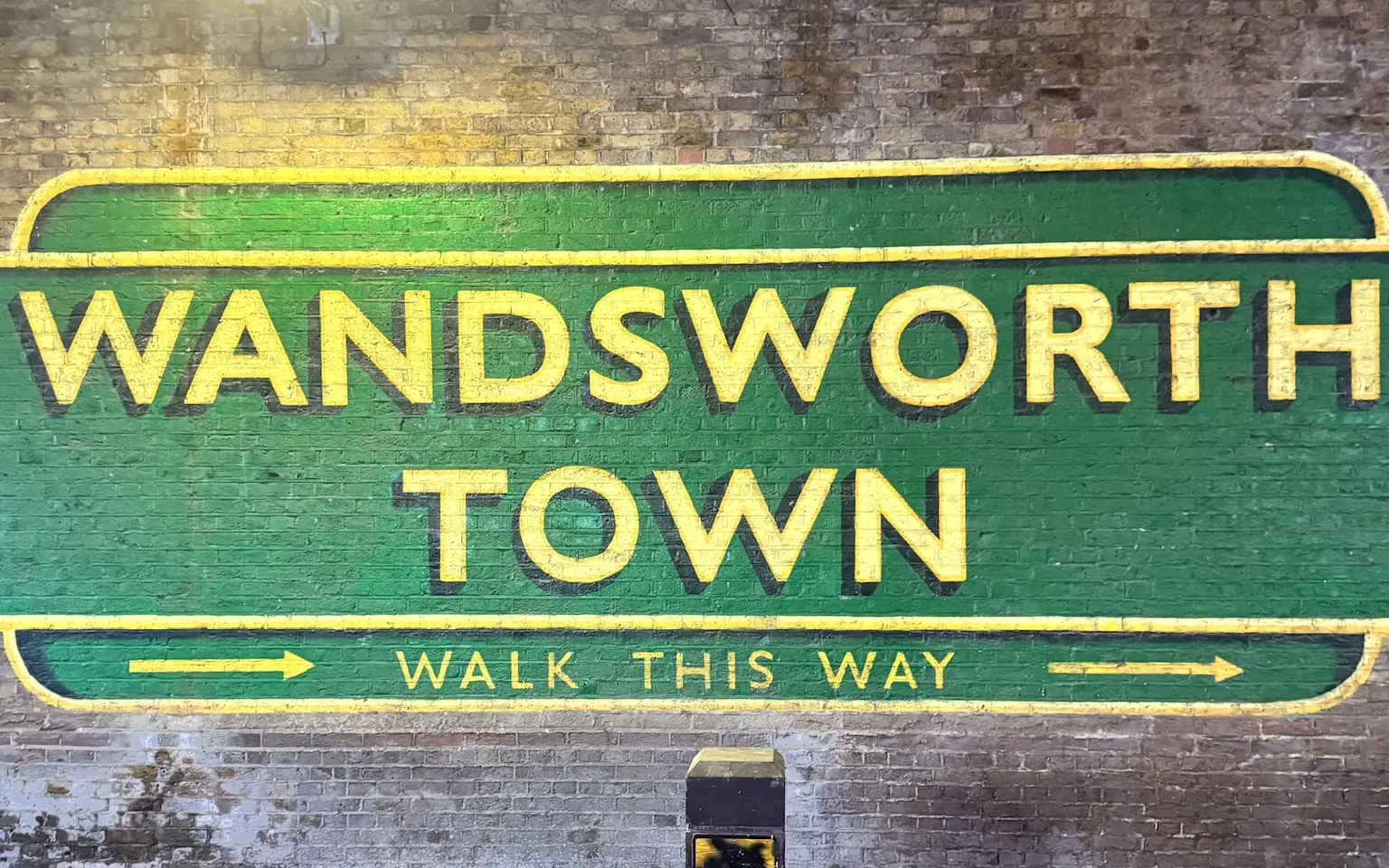 Painted Wandsworth Town sign under the railway arches, SW18