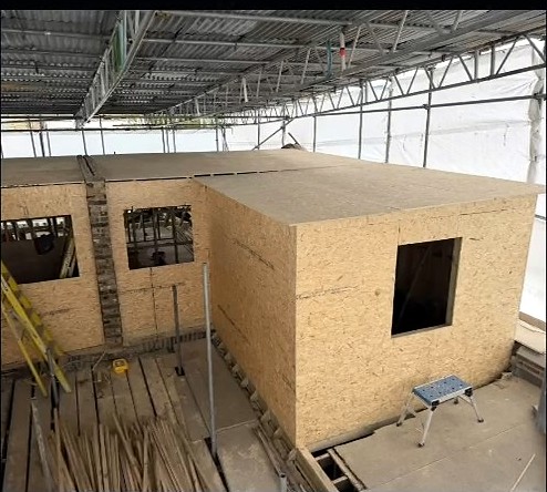 Timber loft structures being formed across two Fulham terraced houses under a weatherproof scaffold