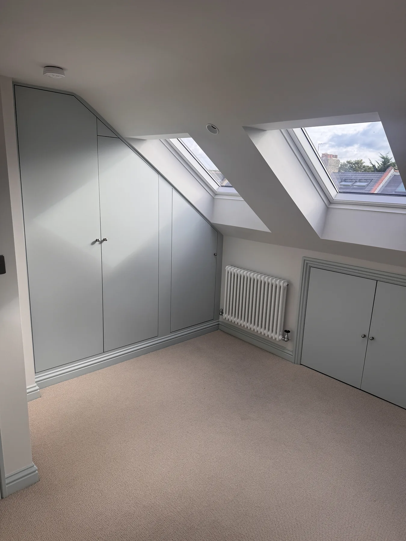 Loft bedroom with rooflights and fitted eaves storage in Wimbledon